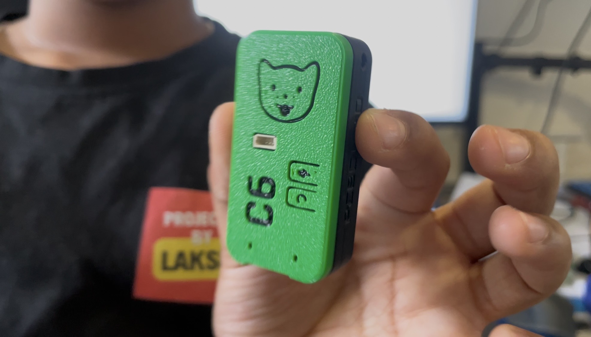 The real AirKords prototype, a small handheld motion controller, held up in a hand